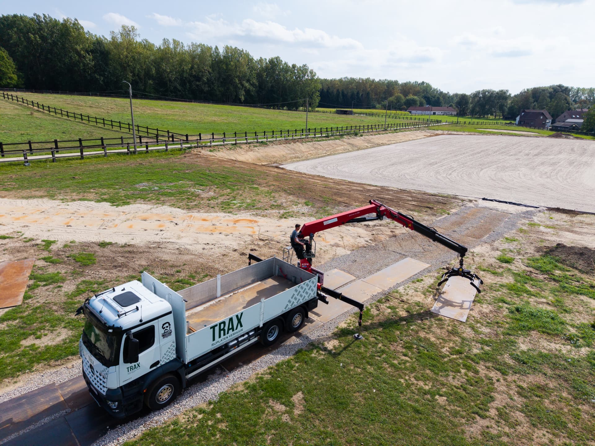 TRAX kraanwagen legt stalen rijplaten op een werf